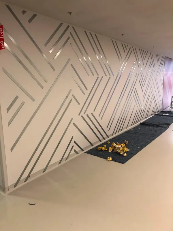 Witte wand met een geometrisch patroon van zilverkleurige lijnen