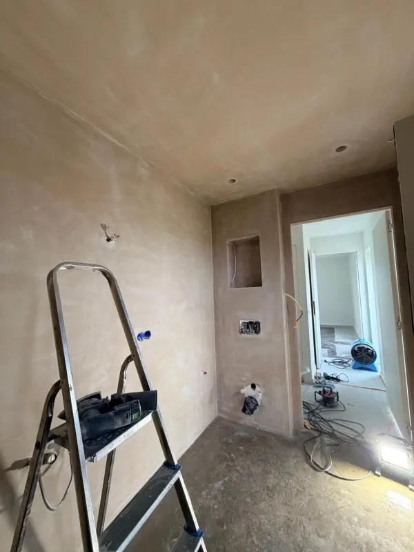 Gang met vers gestucte wanden, plafond en een nis