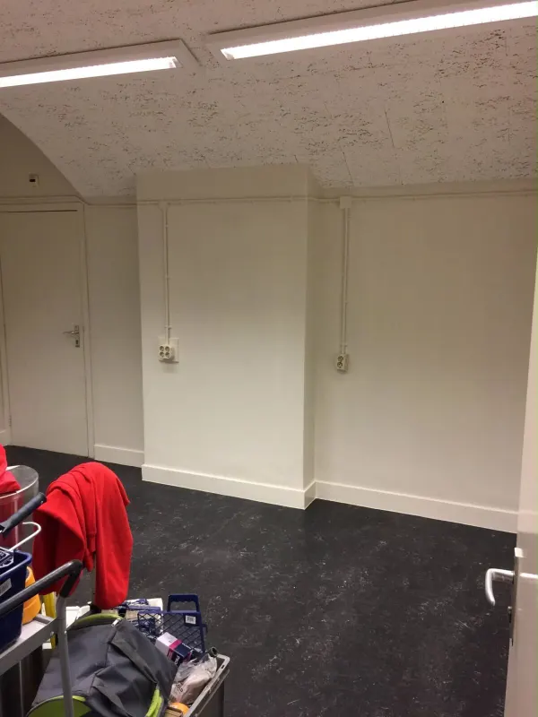 Ruimte met schuin plafond en strak afgewerkte lichte wanden