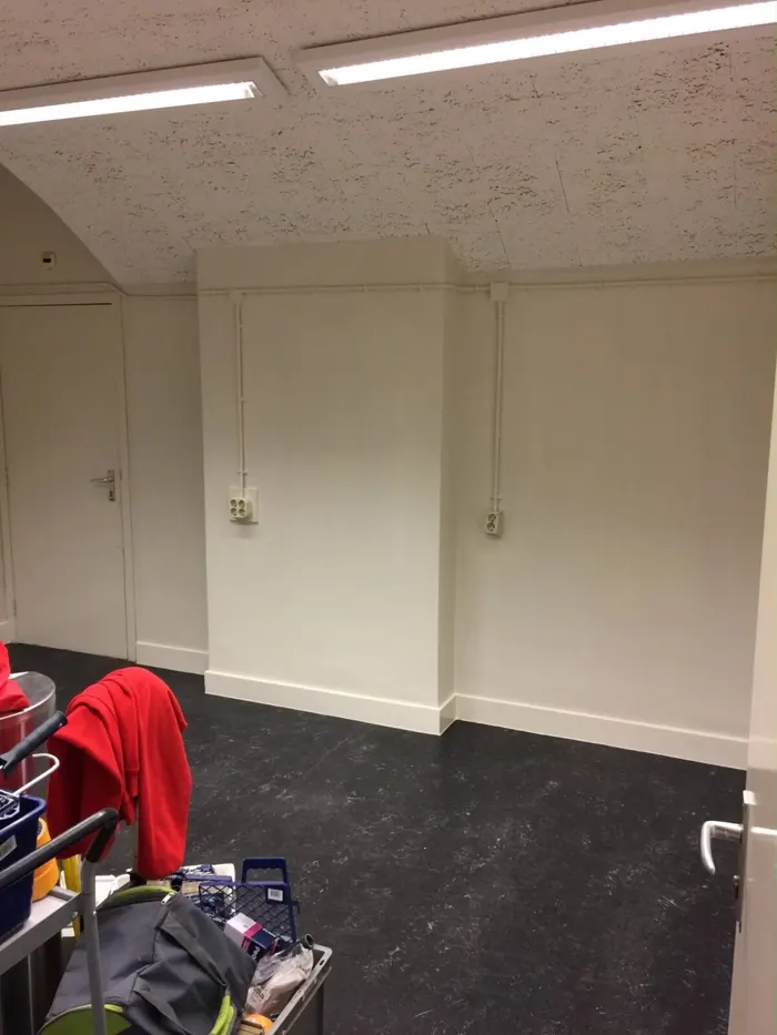 Ruimte met schuin plafond en strak afgewerkte lichte wanden