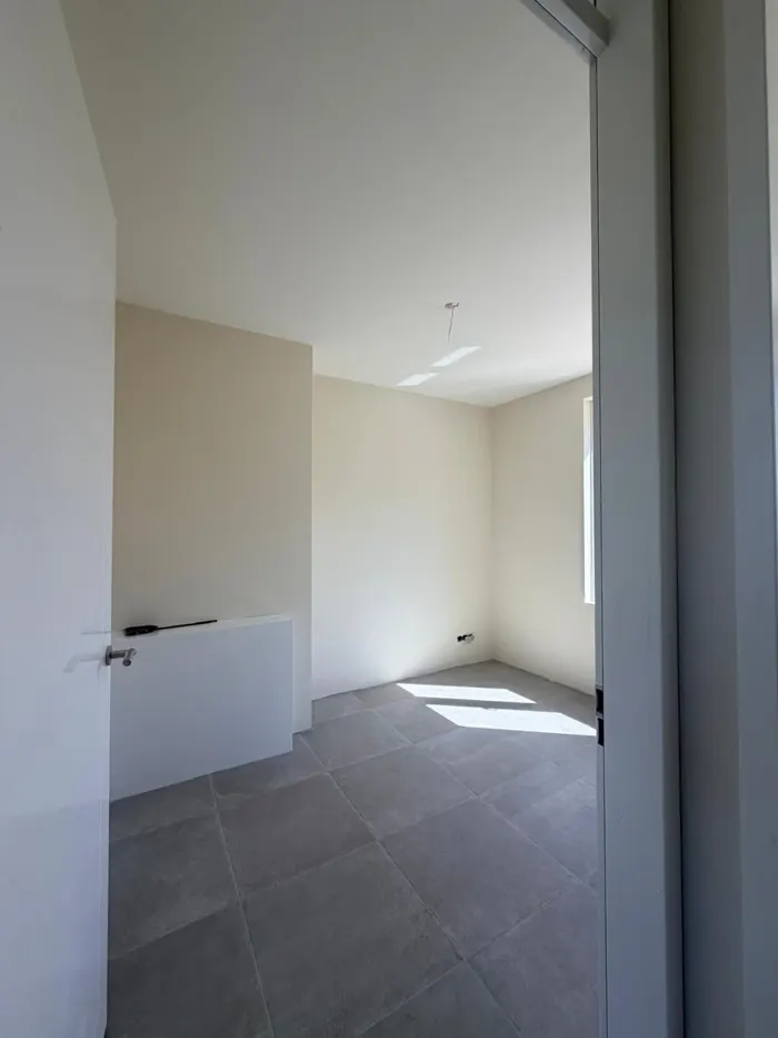 Lege kamer met strak afgewerkte lichte wanden en plafond